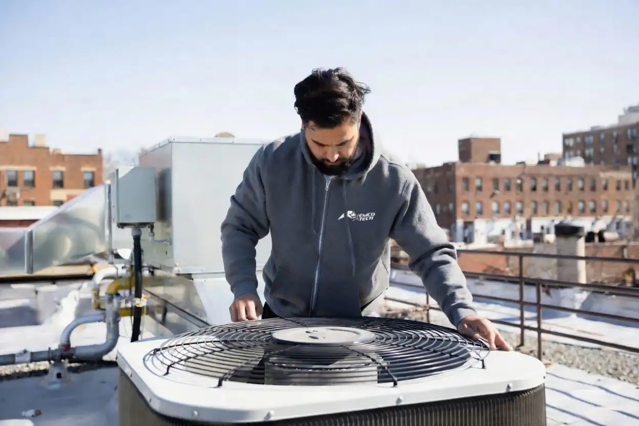 EMCO Tech technician repairing a commercial packaged rooftop HVAC system