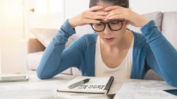 5 Proven Tips to Lower Your AC Bill in Summer - Woman is looking at her electric bill