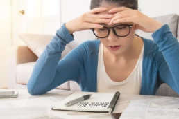 5 Proven Tips to Lower Your AC Bill in Summer - Woman is looking at her electric bill