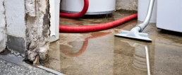 EMCO Tech Leaking Water Heater and HVAC Repair - Flooded Basement with Red Drain Hose