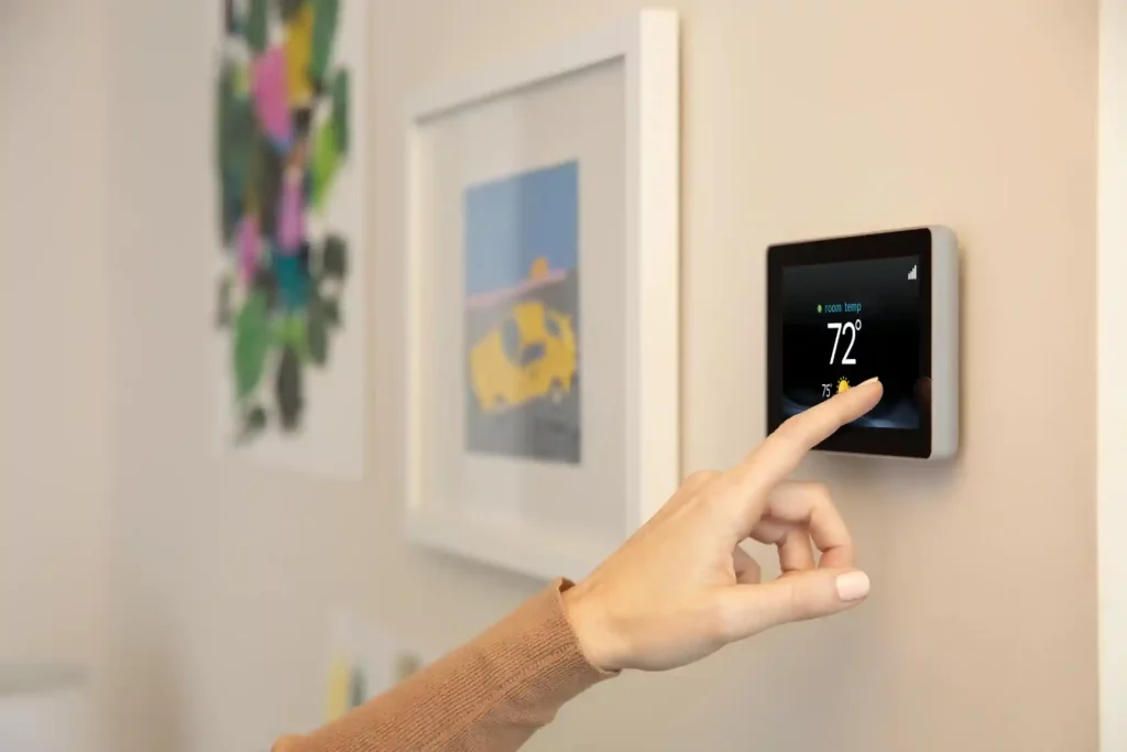 Invest in a Smart Thermostat This Winter - Woman Hand Thermostat