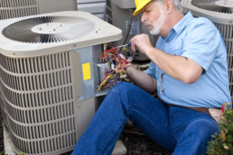 Technician repairing central air conditioning unit