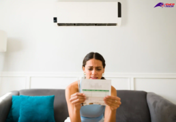 Tips to Lower Your AC Bill - young woman looking over her high Air Conditioning bills