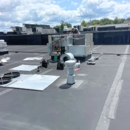 Commercial AC Services in Philadelphia PA - EMCO Tech technician is repairing rooftop package HVAC system