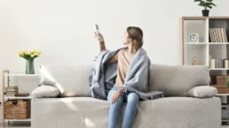 Ductless Minisplit System - Indoor Air Handler - Woman with remote for ductless unit - EMCO Tech Ductless Mini-Split Installation