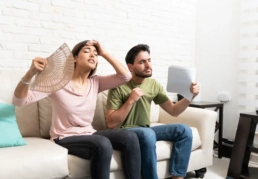How to Know If Your AC Is Low on Refrigerant - Family at home on a hot summer day with a broken air conditioner