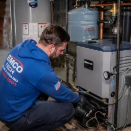 Boiler repair technician inspecting a residential heating system in a Philadelphia basement