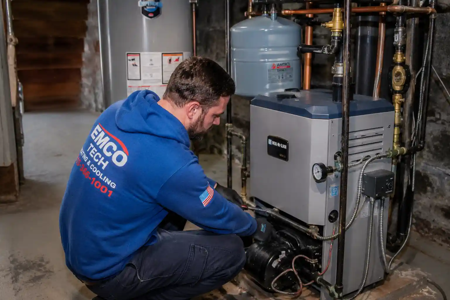 Boiler repair technician inspecting a residential heating system in a Philadelphia basement